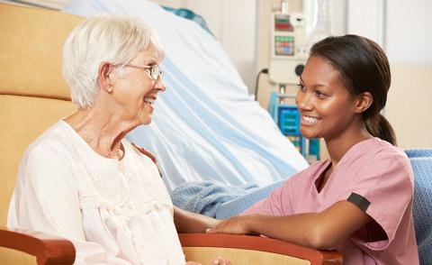 nurse talking to a gray-haired patient