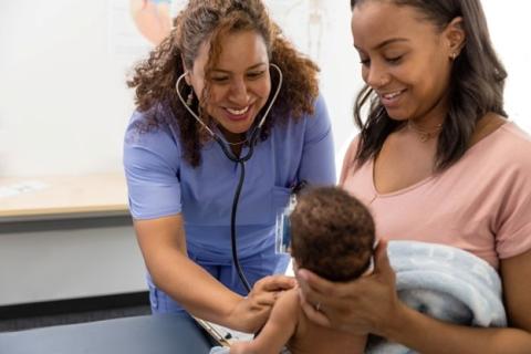 A family nurse practitioner listens to an infant’s heart and lungs with a stethoscope. 