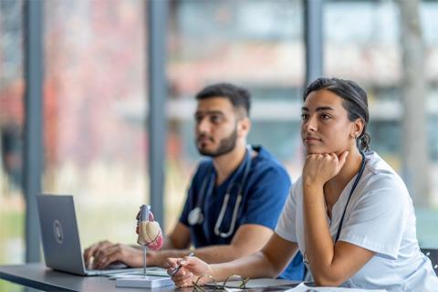 Nurses studying at a desk.